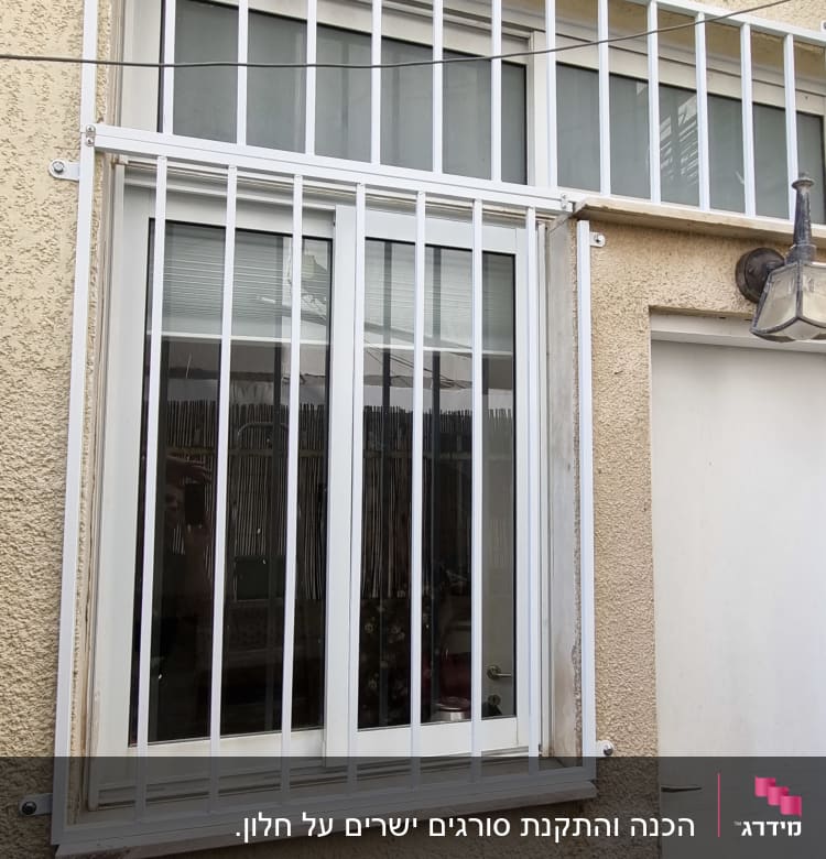 חלון עם סורגים לבנים על קיר חיצוני